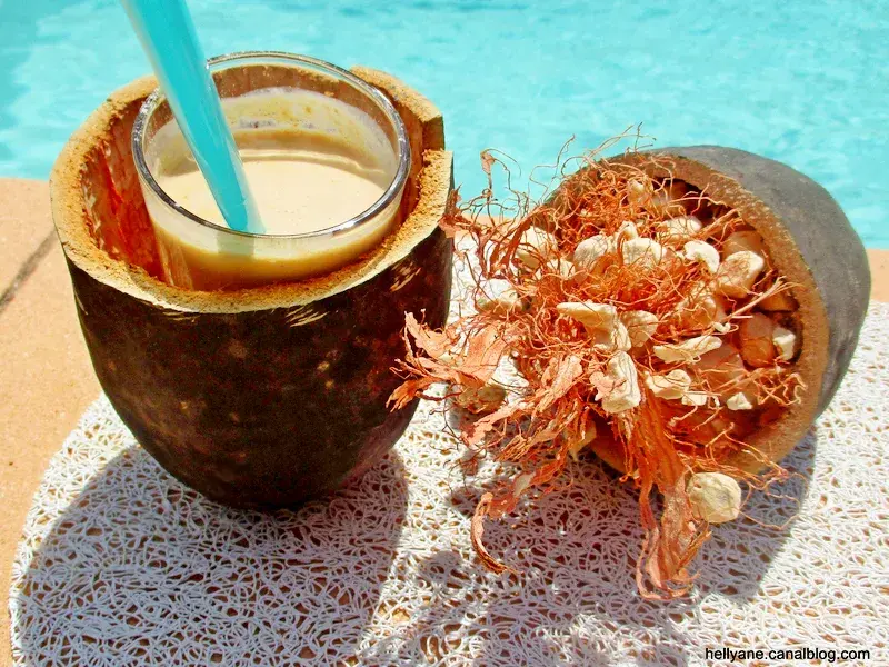 Boisson au baobab servie dans une coque de fruit, à côté de la pulpe séchée